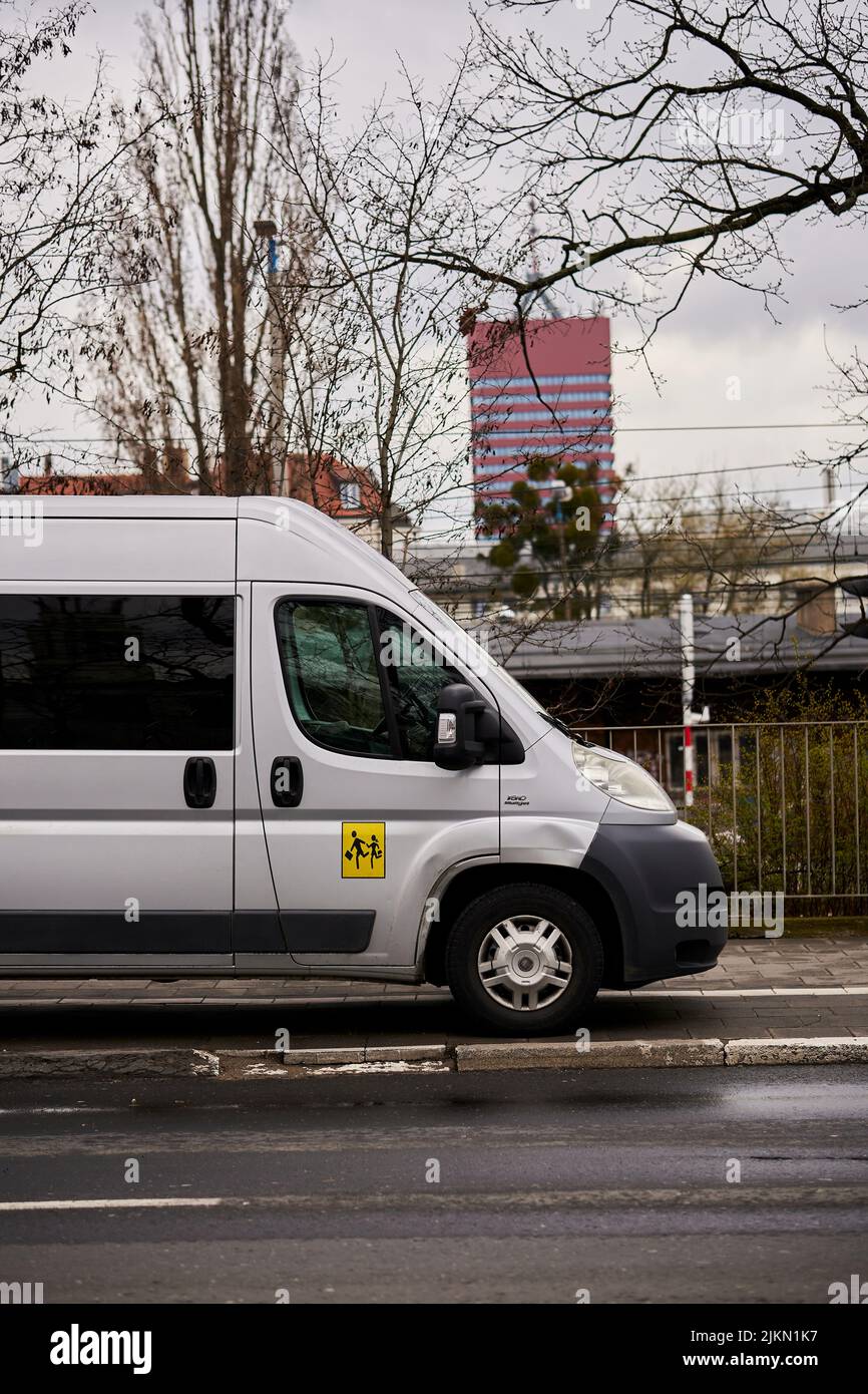 Ein geparkter Schultransportwagen auf einem Bürgersteig im Stadtzentrum an einem regnerischen Tag Stockfoto