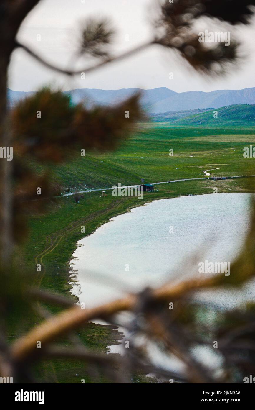 Eine vertikale Aufnahme des Sees, umgeben von grünen Hügeln. Stockfoto