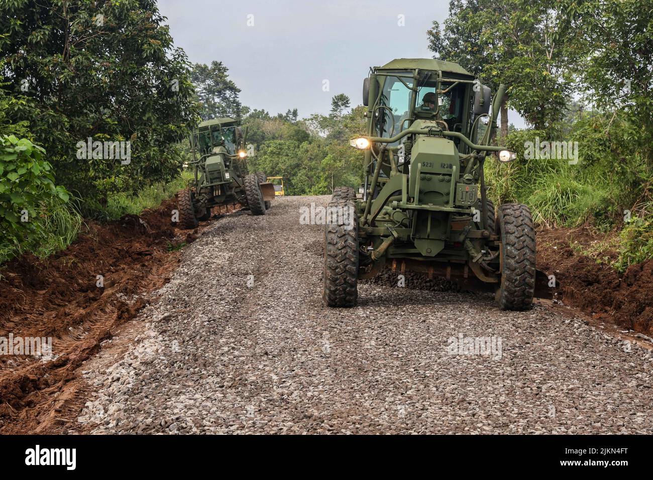 Lote der 130. Engineer Brigade, 84. Engineer Bataillon streut bei gemeinsamen Straßenreparaturarbeiten im Python 1 Range, Baturaja, Indonesien, 31. Juli 2022, Schotter mit einem 120m Motor Grader aus Als Teil von Garuda Shield 2022. Garuda Shield, ein Teil der Operation Pathways und eine langjährige jährliche, bilaterale Militärübung zwischen dem US-Militär und den nationalen Streitkräften Indonesiens, verstärkt die Verpflichtungen der USA gegenüber unseren Verbündeten und regionalen Partnern, die gemeinsame Bereitschaft und die Interoperabilität, gemeinsam zu kämpfen und zu gewinnen. (USA Armeefoto von Sgt. Kyler Chatman, 8. Theatre Sustainment Stockfoto