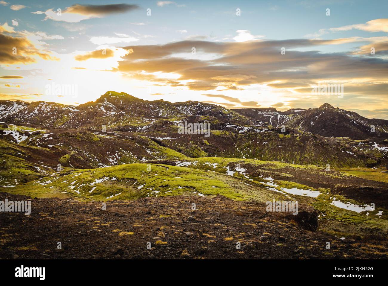 Eine schöne Landschaftsansicht von verschneiten Bergen auf Grasland mit einem bewölkten Himmel in Rangarping, Eystra Southern, Island Stockfoto