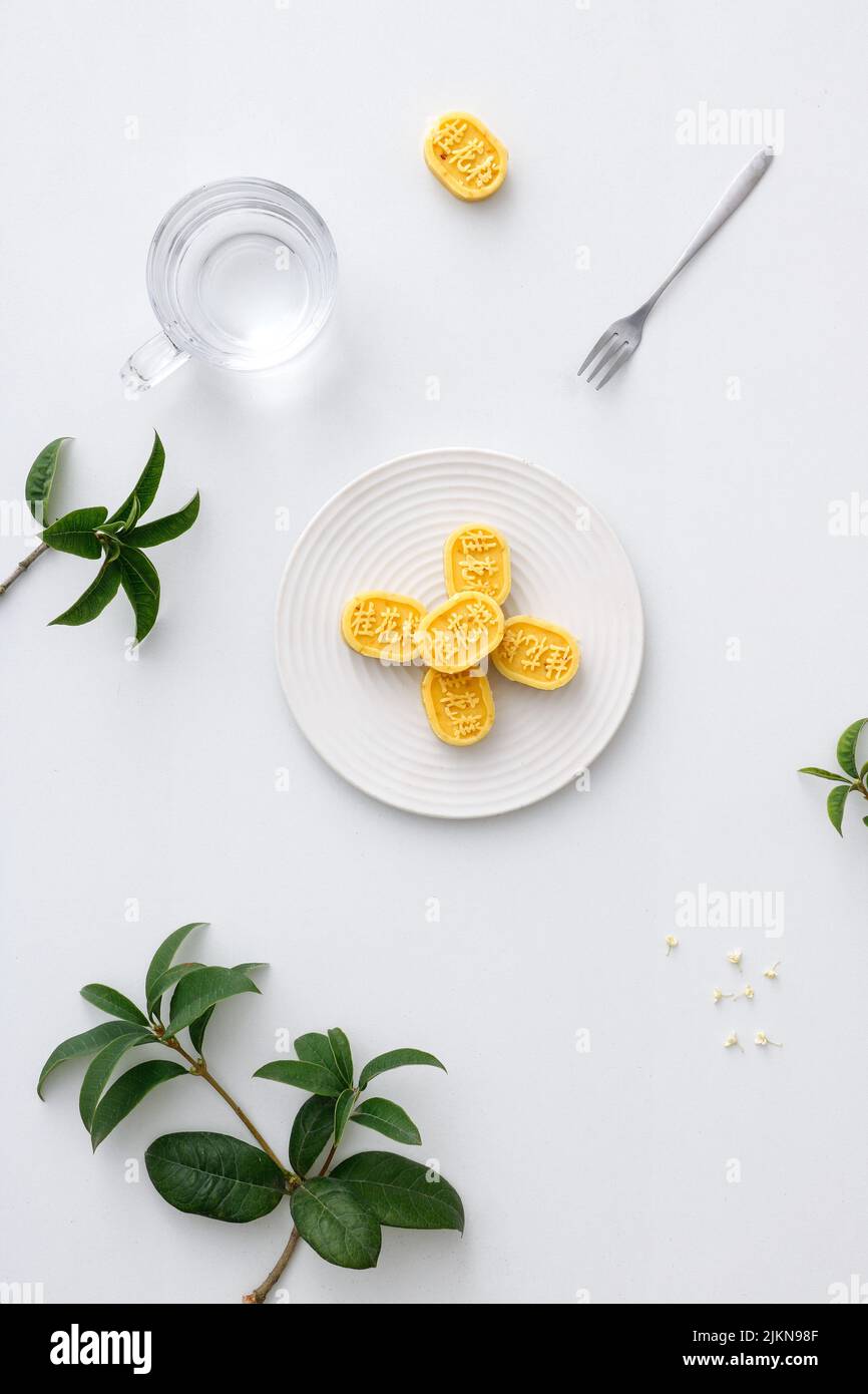 Eine vertikale Aufnahme ästhetischer Tischaufstellung mit traditionellem chinesischen Osmanthus-Kuchen Stockfoto