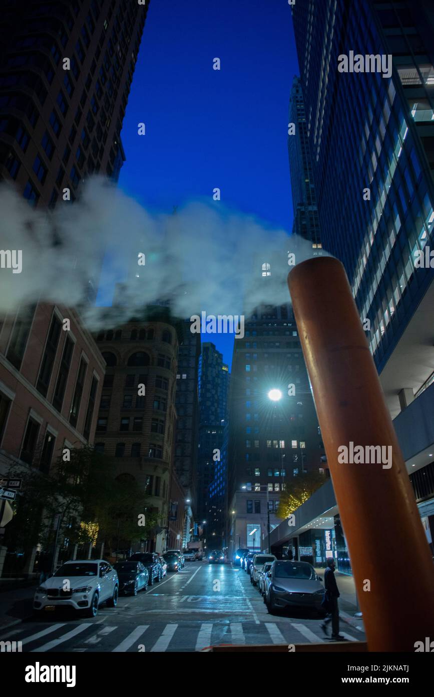 Eine vertikale Aufnahme einer Dampfrohrentlüftung in einer kalten Nacht in Manhattan, New York, USA Stockfoto