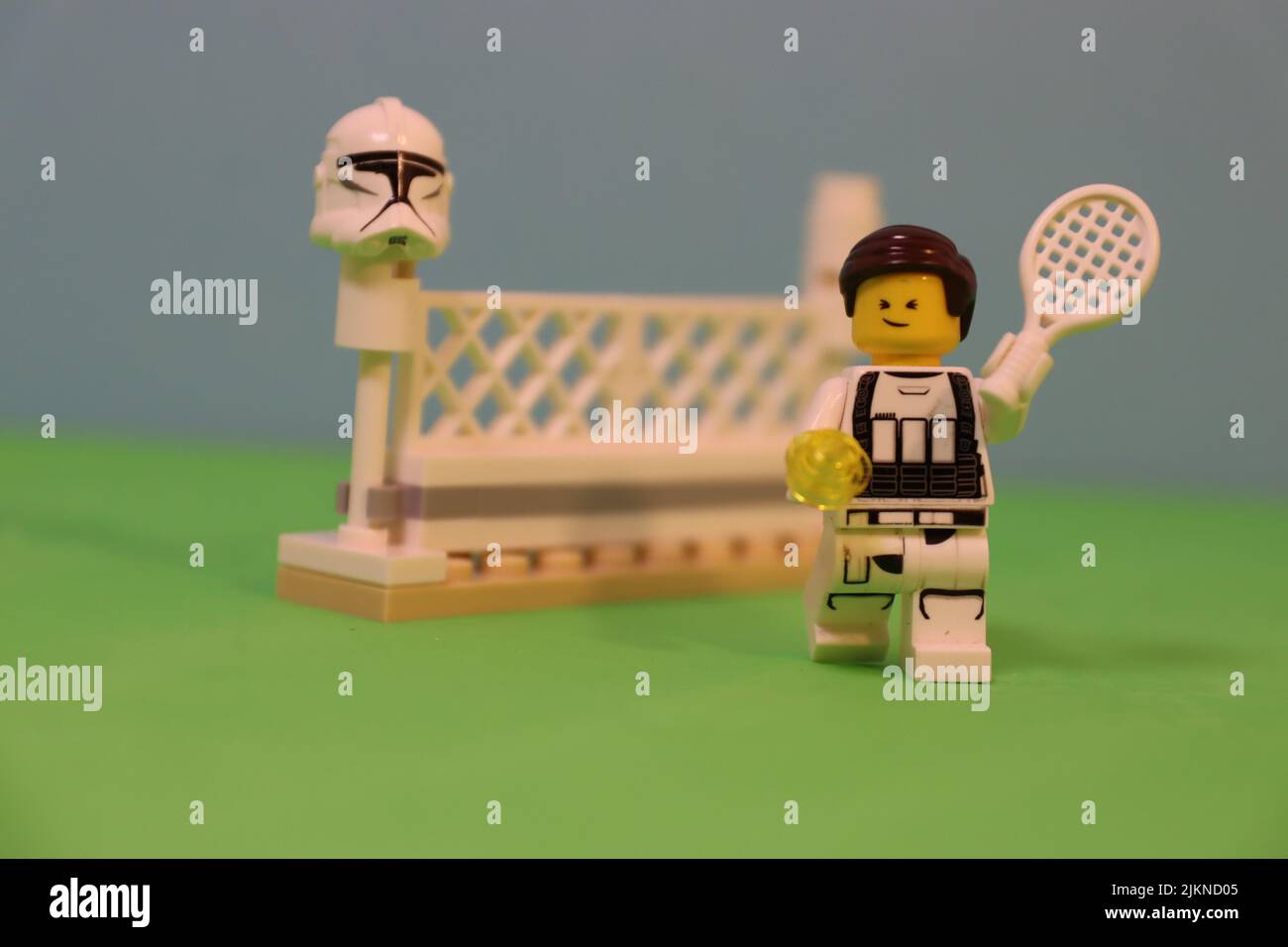 Die Lego-Spielzeugfigur eines männlichen Tennisspielers mit einem Raquet auf einem Platz Stockfoto