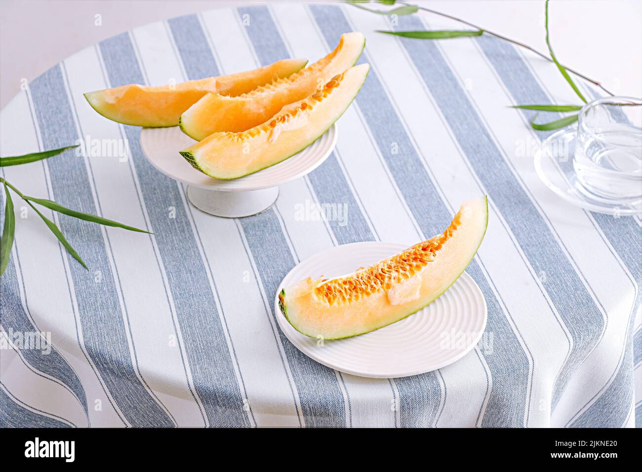 Eine Aufnahme aus Melonenscheiben auf dem Tisch mit gestreifter Tischdecke Stockfoto