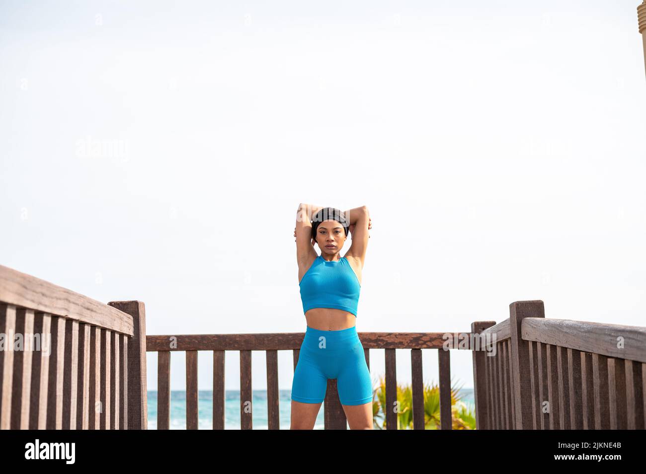 Eine hübsche afroamerikanische Frau, die an einem sonnigen Tag am Strand Sport macht Stockfoto