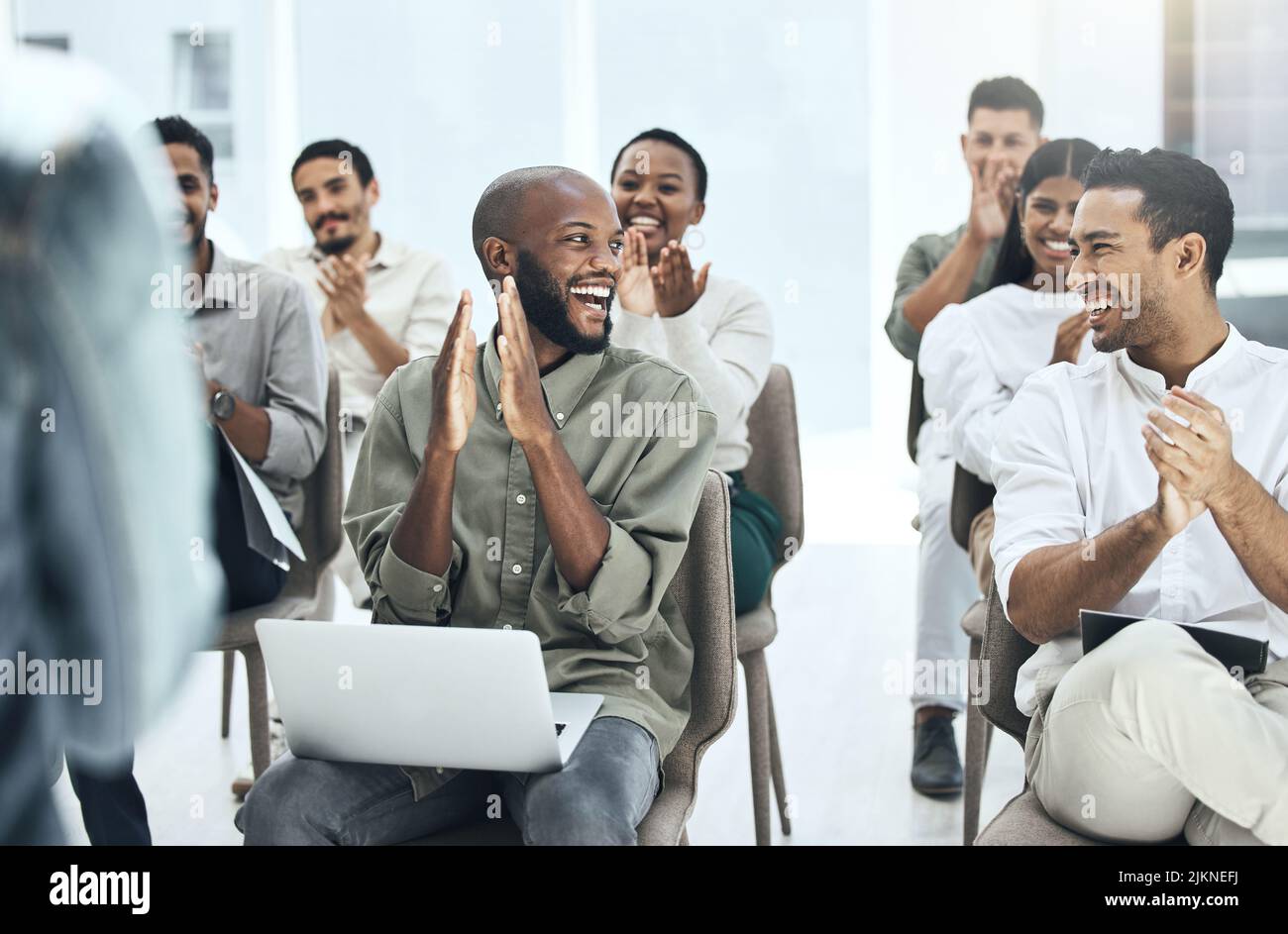 Das war ausgezeichnet, richtig. Eine Gruppe von Leuten klatschte und lächelte während eines Treffens bei der Arbeit. Stockfoto