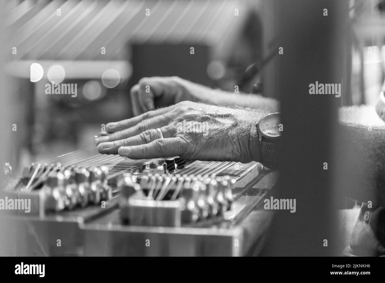 Eine Graustufenaufnahme der Hände eines Slide-Gitarristen Stockfoto
