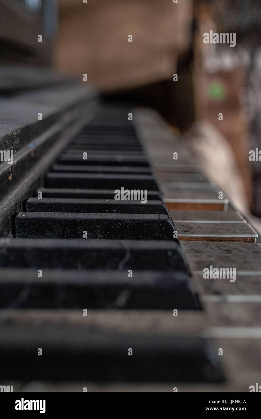 Ein gebrochenes Vintage-Klavier mit schmutzigen Klavierschlüsseln in einem verlassenen Lagerhaus Stockfoto