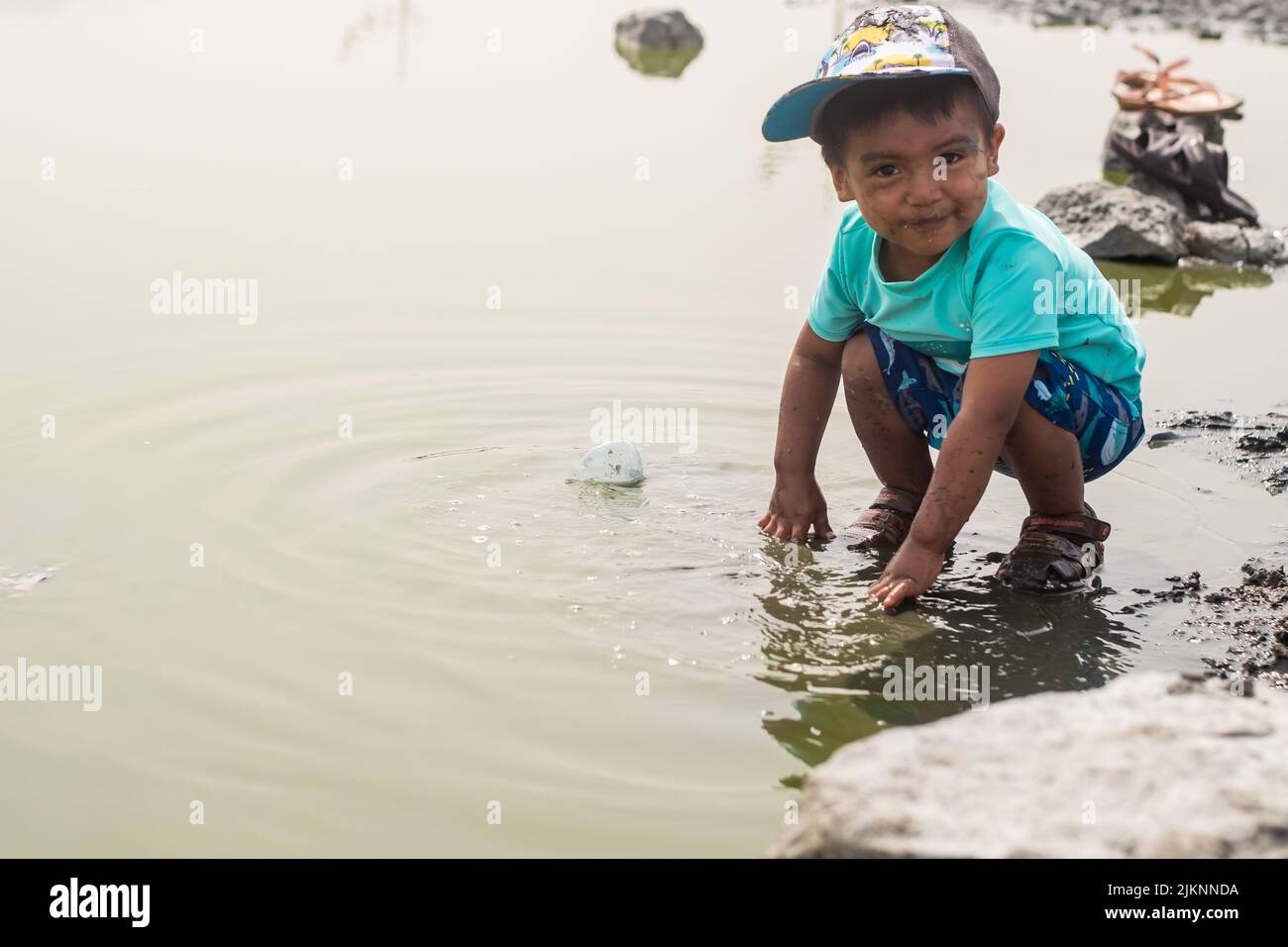 Ein lateinischer Junge, der in einer natürlichen Lagune spielt Stockfoto