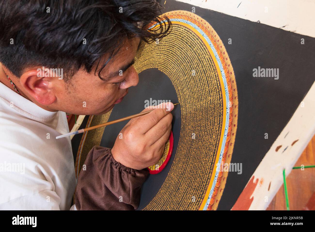 Lhasa, Tibet - 3. August 2022: Tibetischer Künstler malt das buddhistische Mantra Om Mani Padme Hum Stockfoto