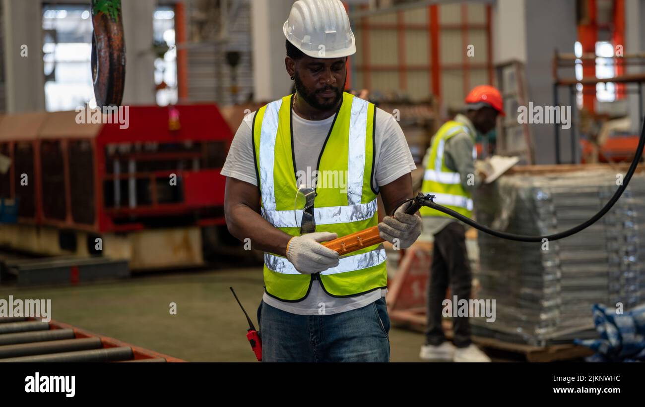 African american Vorarbeiter oder Arbeiter Kontrolle Industriekran Hersteller Lieferant für die Verladung in Factory Production Line Stockfoto