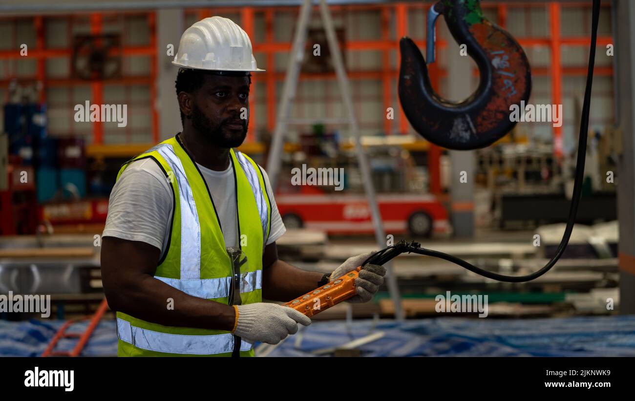 African american Vorarbeiter oder Arbeiter Kontrolle Industriekran Hersteller Lieferant für die Verladung in Factory Production Line Stockfoto
