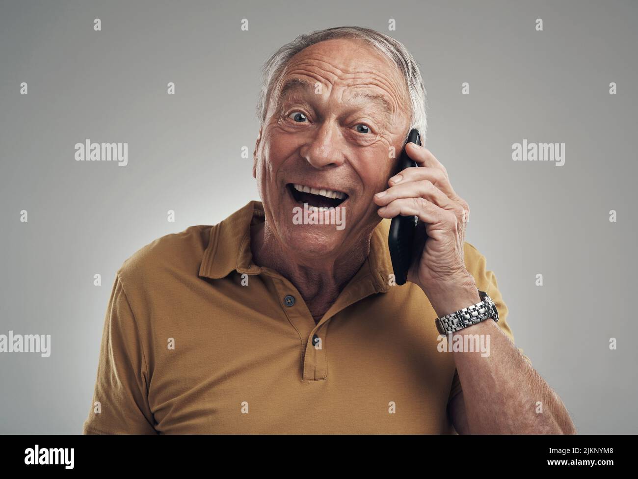 Du wirst ein Opa sein. Studioaufnahme eines älteren Mannes, der sein Handy vor grauem Hintergrund benutzte. Stockfoto