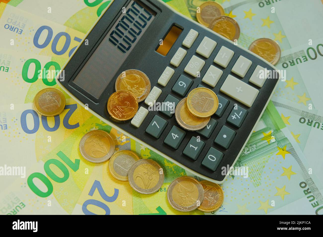 .Rechner und Euro-Münzen auf Euro-Banknoten Hintergrund.Steuern in EU-Ländern.Euro-Währung.Budgetzuweisung.Neuberechnung von Geld. Ausgaben und Stockfoto