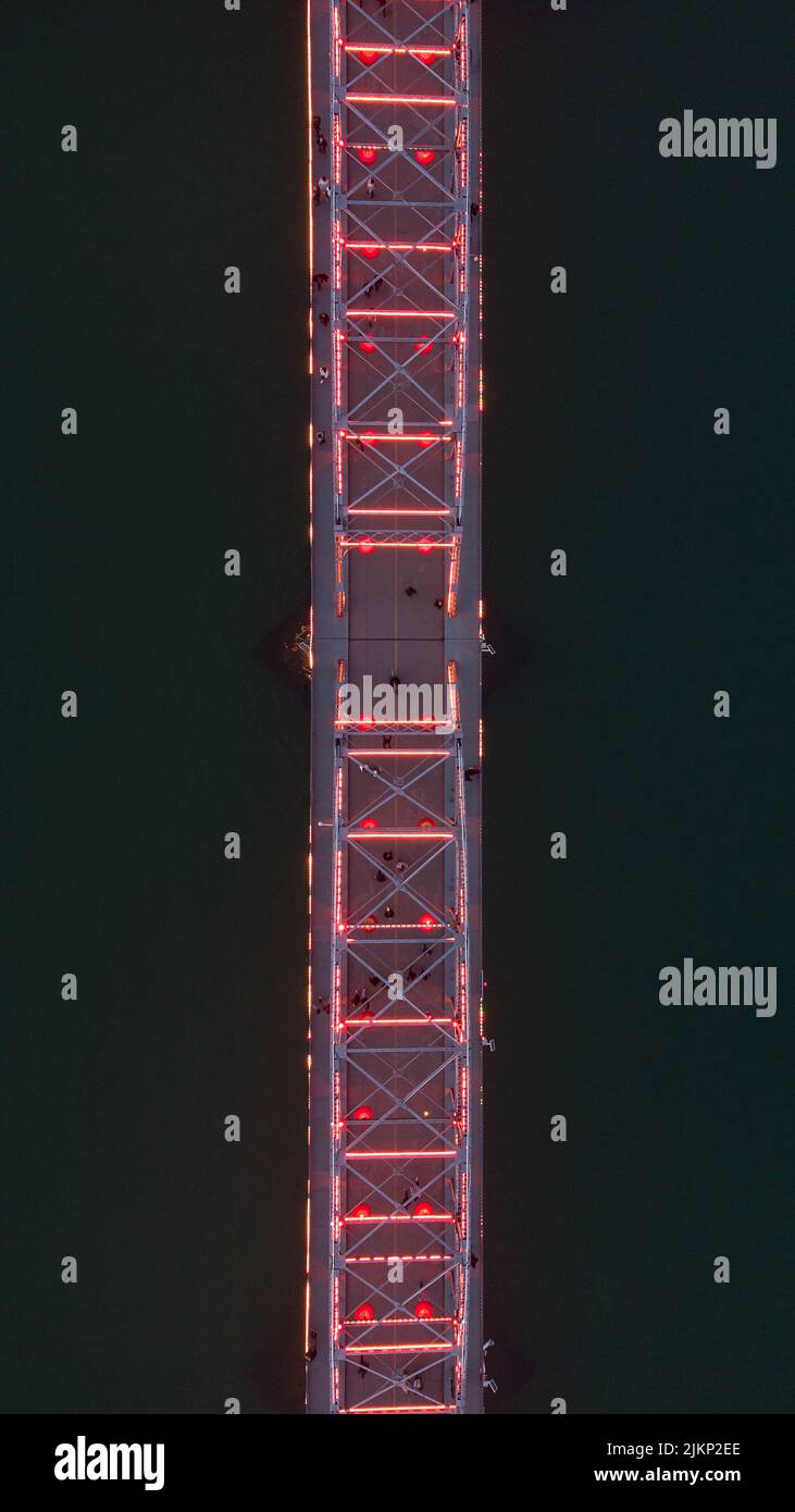 Eine Luftaufnahme einer Brücke, die nachts von den Lichtern beleuchtet wird Stockfoto