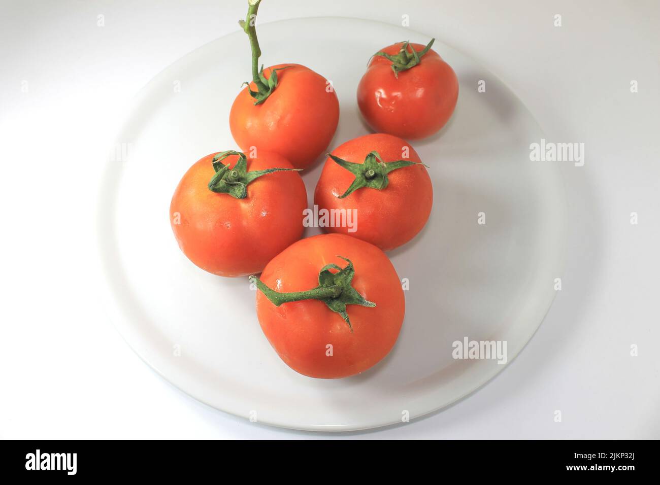 Eine Nahaufnahme von kupferfarbenen Tomaten auf einem weißen Teller Stockfoto