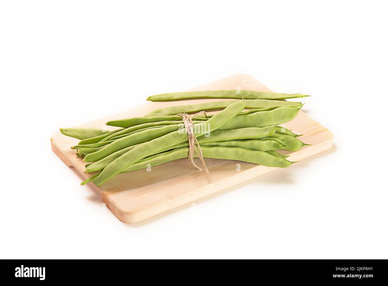 Eine Nahaufnahme von grünen Bohnen auf einem Schneidebrett, isoliert auf weißem Hintergrund Stockfoto
