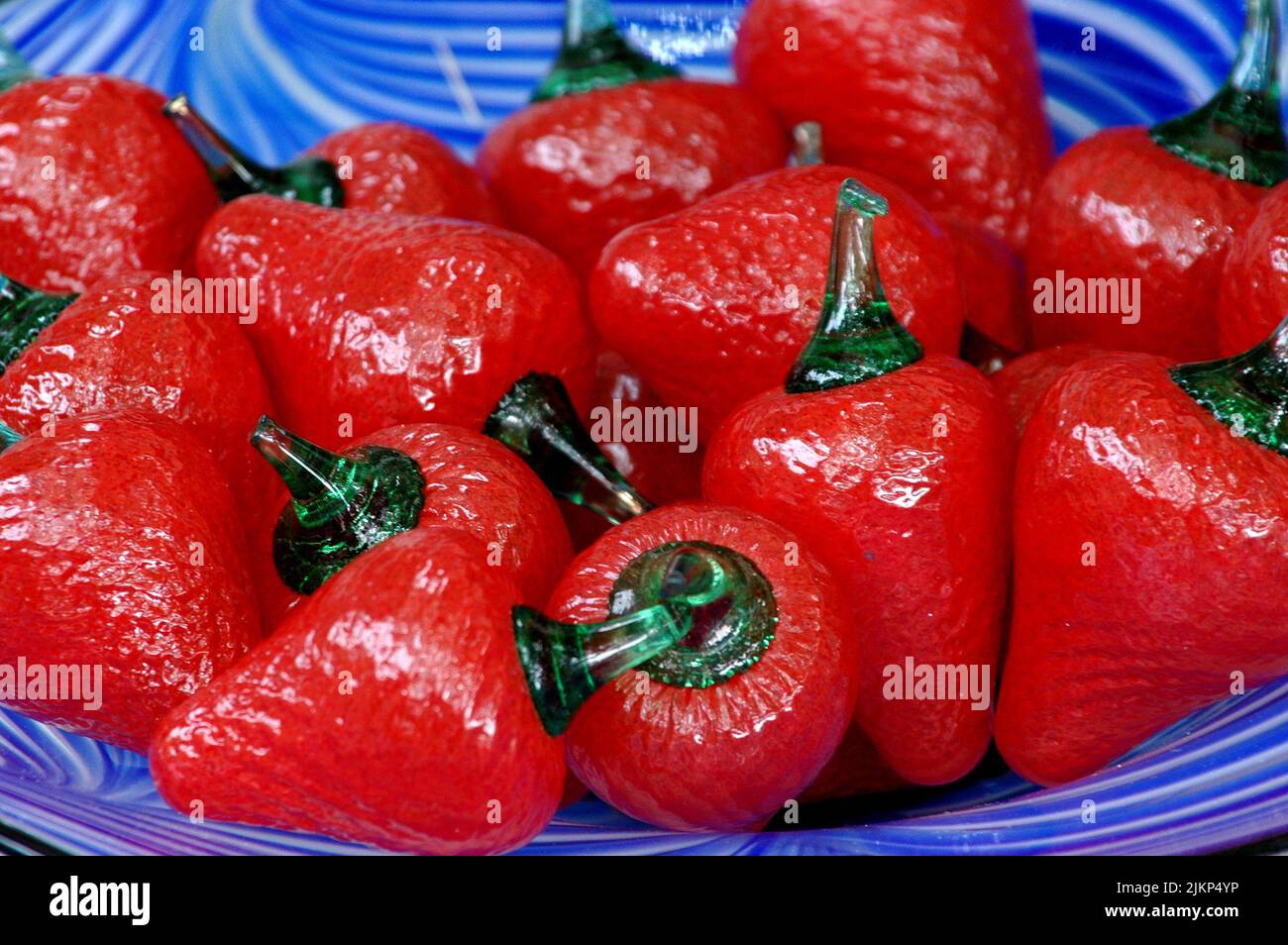 Eine Nahaufnahme von gefälschten roten Paprika in einer blauen Schüssel Stockfoto