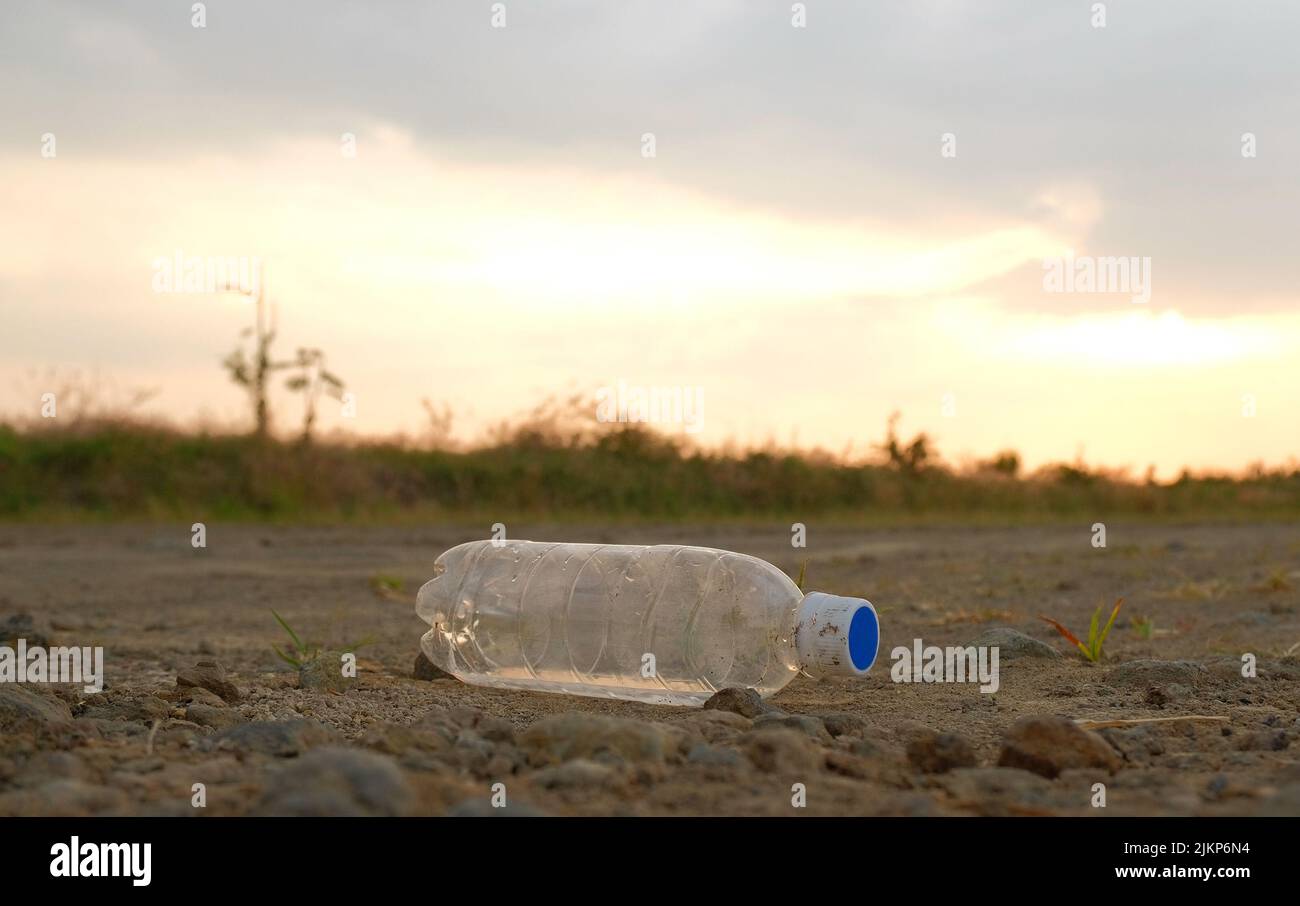 Eine Plastikflasche in der Mitte einer unbefestigten Straße Stockfoto