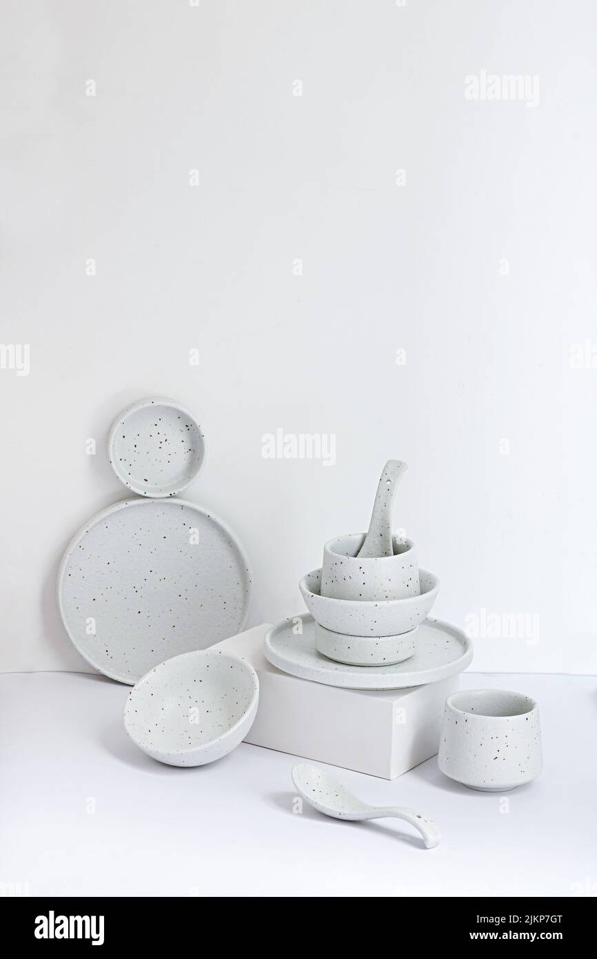 Eine vertikale Zusammensetzung aus Geschirr vor weißem Hintergrund Stockfoto