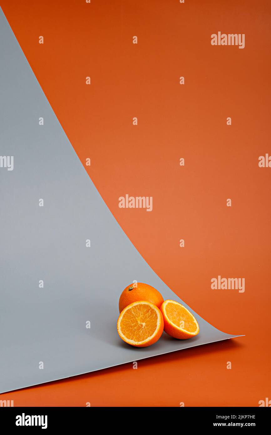 Eine vertikale Komposition aus Orangen vor orangefarbenem Hintergrund Stockfoto