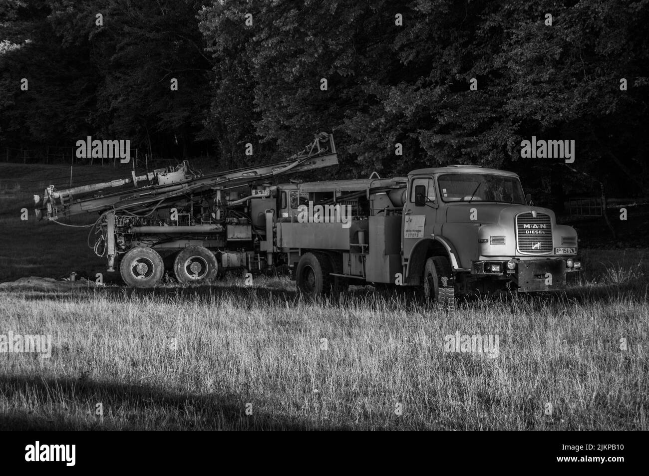 Zwei alte blaue Lastwagen mit Kran auf dem Feld verlassen Stockfoto