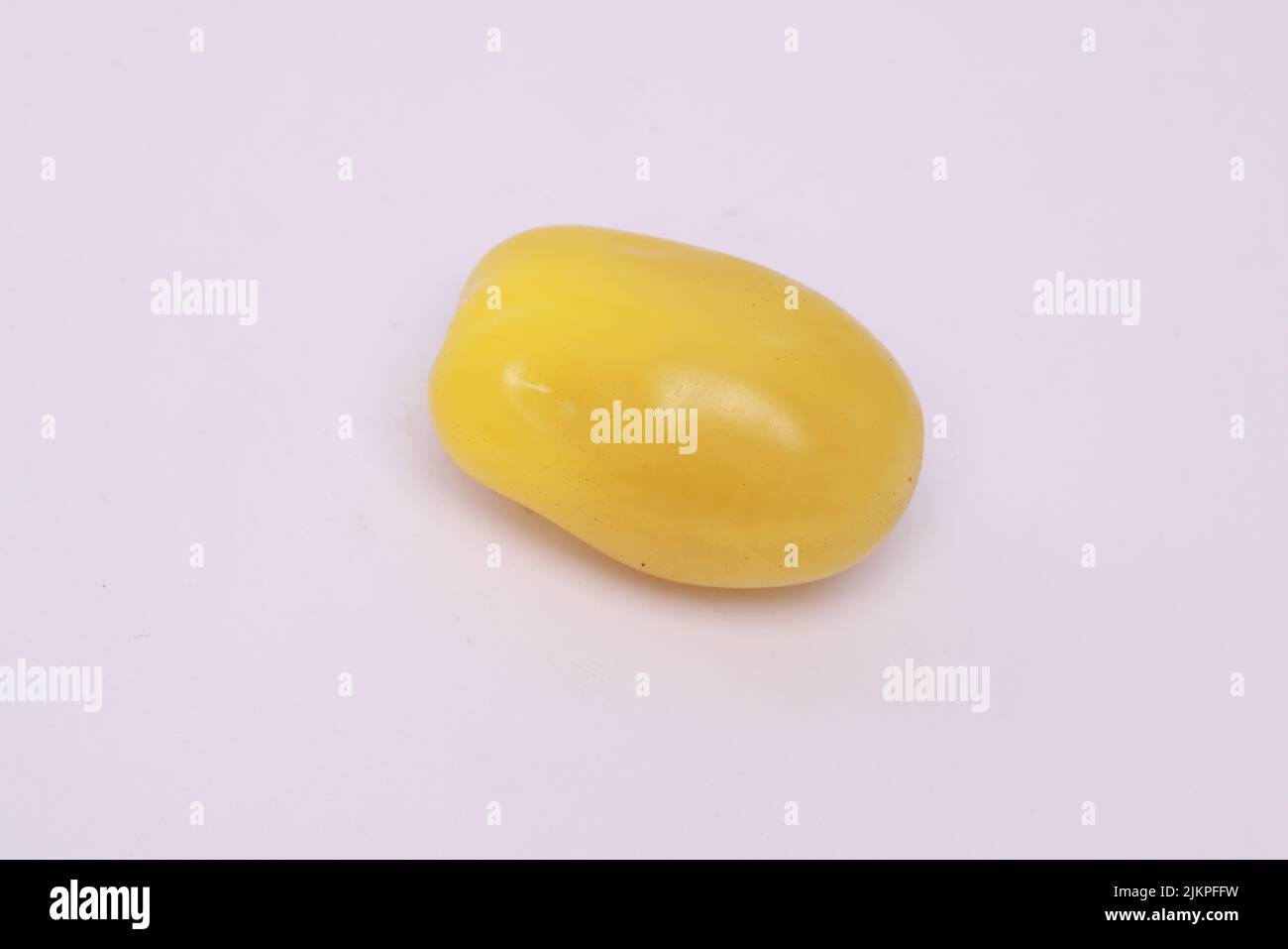 Eine Nahaufnahme einer gelben Kirschtomate, isoliert auf weißem Hintergrund Stockfoto