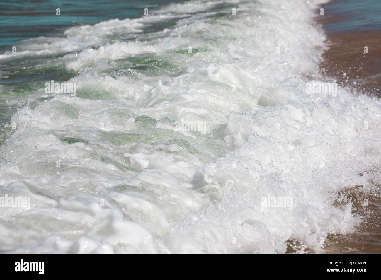 Spritzer von frischem schäumenden, sprudelnden Meerwasser, verrückten Whirlpoolwellen, weißen Wellenwappen, Sandy Coast of Baltic Sea, Polen. Stockfoto