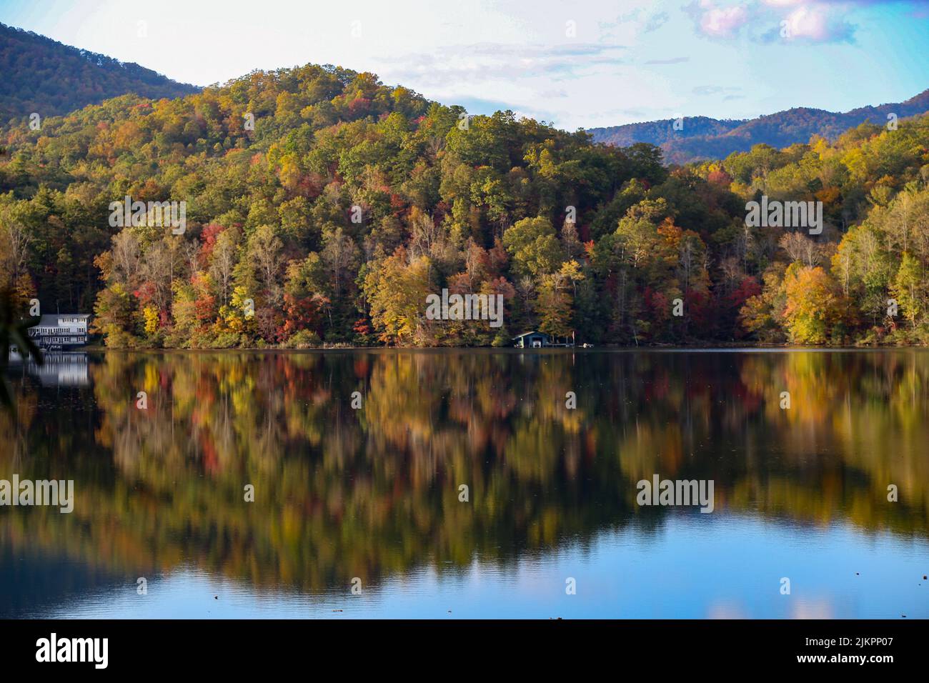 Die schöne Aufnahme einer Seenlandschaft mit Blick auf den herbstlichen Wald auf den See und einer Wasserspiegelung von Bäumen Stockfoto