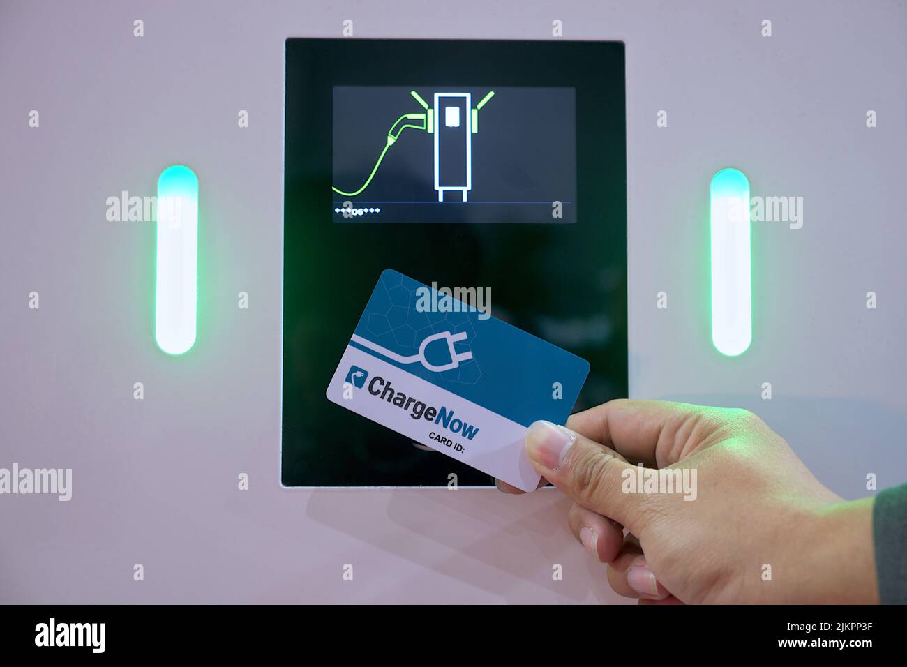 Nahaufnahme eines Geschäftsmannes, der Smartcard-Touch auf dem Monitorsensor für den Akku verwendet, um Elektrofahrzeuge oder Elektroautos zu erreichen Stockfoto