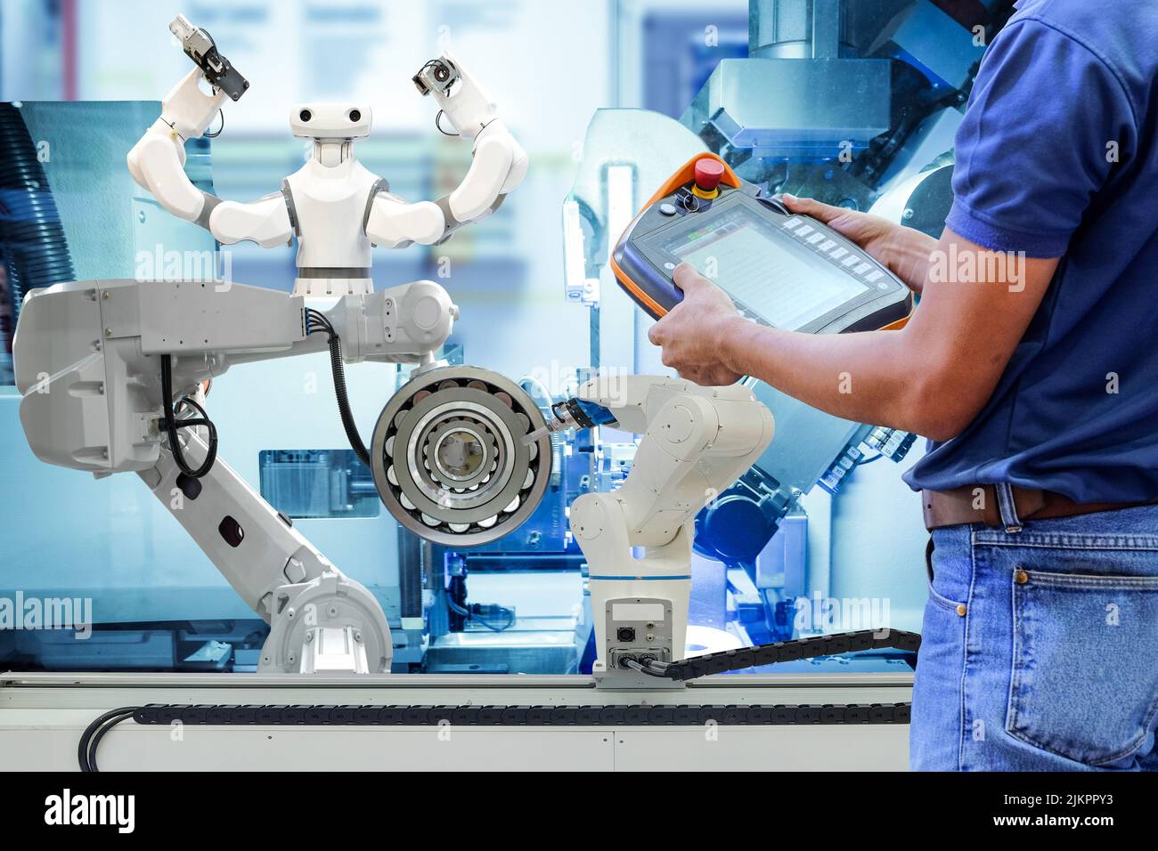 Techniker aus der Nähe, der mithilfe einer drahtlosen Fernbedienung ein Programm zur Steuerung der Industrierobotik einführt, um die Automatisierung über die Linienproduktion zu erledigen Stockfoto