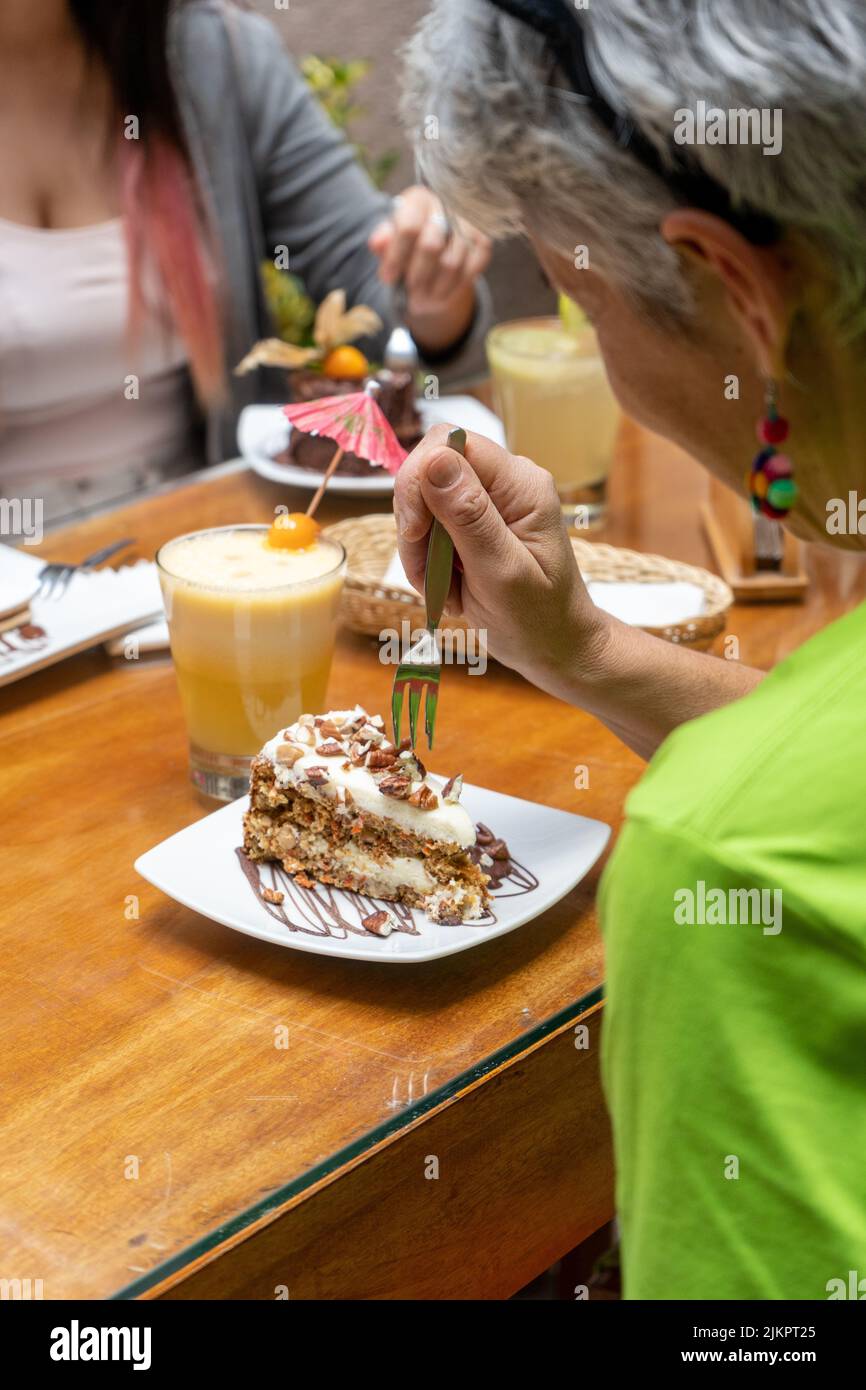 Ein Porträt einer alten Frau, die in einem Restaurant mit einer anderen Frau isst Stockfoto