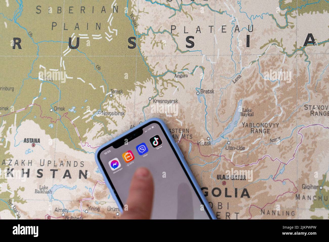 Das Tik-Tok-Logo auf dem Smartphone-Bildschirm vor dem Hintergrund der Karte von Russland. Das Konzept eines TikTok-Verbots in Russland. Der Finger ist aus FOC Stockfoto