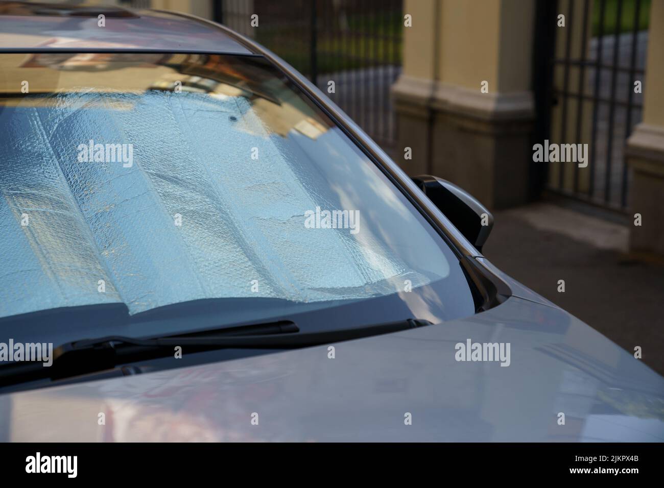 Reflektierende Schutzfläche unter der Windschutzscheibe des Autos an heißen Tagen, beheizt durch Sonnenstrahlen im Auto Stockfoto