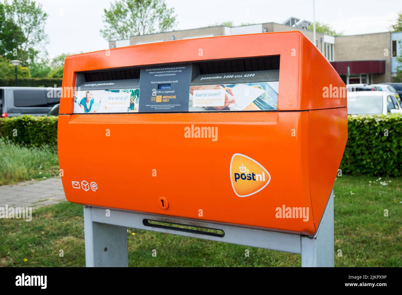PostNL orangefarbener Briefkasten mit Logo. Briefkasten des niederländischen Postunternehmens. Hertogenbosch, Niederlande - 7. Mai 2022. Stockfoto