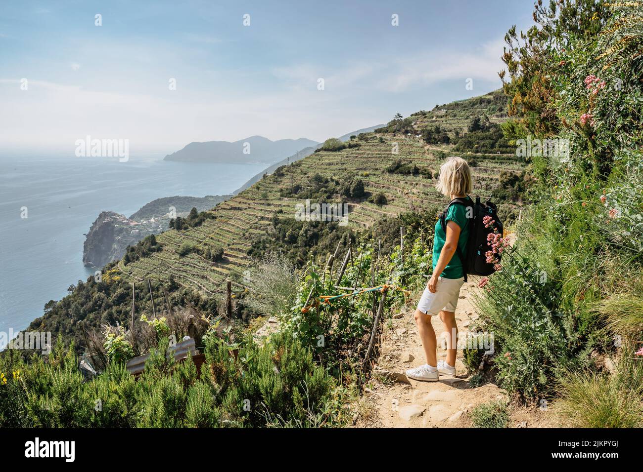 Aktive sportliche Mädchen Wandern in Cinque Terre, Italy.View der Küste und Sea.Woman Backpacker auf steilen Klippen genießen Freiheit, Abenteuer, Sommerurlaub. Stockfoto