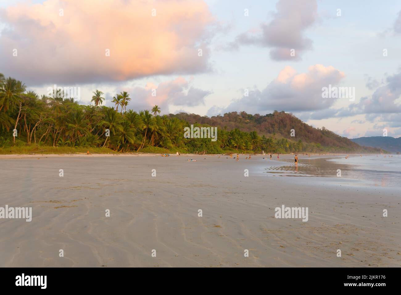 Sandstrand in Santa Teresa, Costa Rica. Nicht erkennbare Menschen genießen Meeresurlaub. Stockfoto