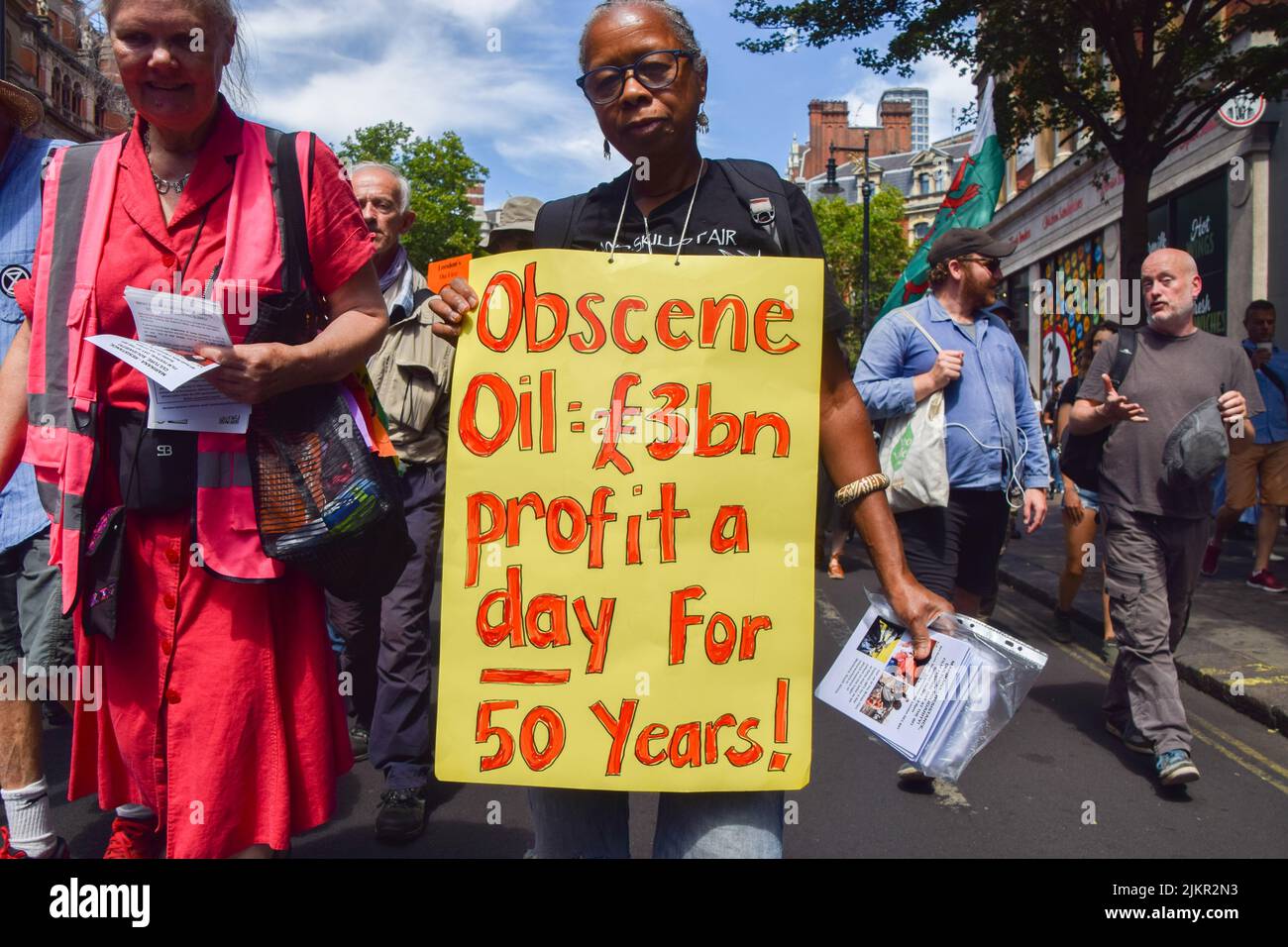 London, Großbritannien. 23.. Juli 2022. Ein Protestler hält ein Zeichen, das besagt, dass Ölgesellschaften seit 50 Jahren einen Gewinn von £3 Milliarden pro Tag machen. Demonstranten von Just Stop Oil, Extinction Rebellion, Isolate Britain und anderen Gruppen veranstalteten einen marsch durch das Zentrum Londons, in dem sie die Regierung aufforderten, fossile Brennstoffe zu beenden, große Umweltverschmutzer und Milliardäre zu besteuern, alle Häuser zu isolieren und gegen das Klima und die Lebenshaltungskosten zu handeln. Stockfoto