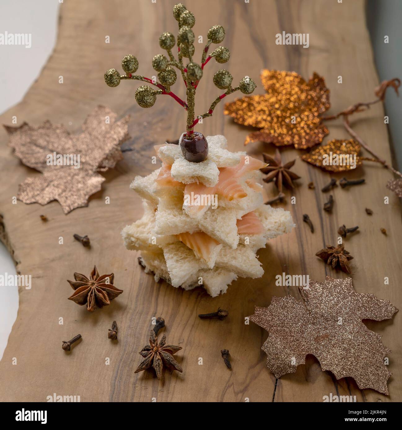 Ein Weihnachtsbaum wurde aus Brotscheiben und geräuchertem Lachs mit anderen Weihnachtsdekorationen hergestellt Stockfoto