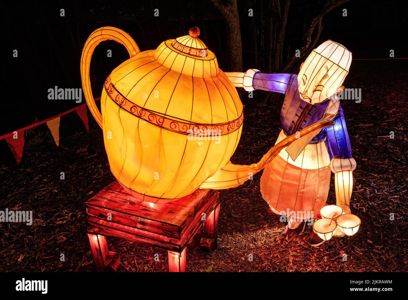 Chinesische Neujahrslaterne Kunst. Ein Mann gießt Tee aus einer riesigen Teekannen Stockfoto
