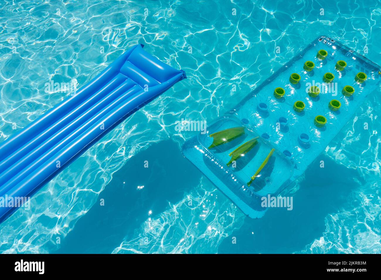 Klare blaue Sommerliegen schweben auf einem geriffelten Swimmingpool Stockfoto