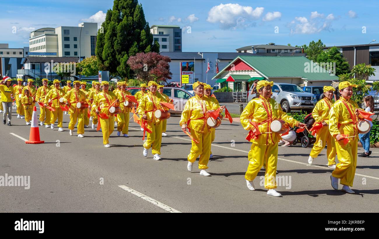 Mitglieder von Falun Dafa oder Falun Gong, einer chinesischen religiösen Bewegung, marschieren und spielen Hüfttrommeln in Rotorua, Neuseeland Stockfoto