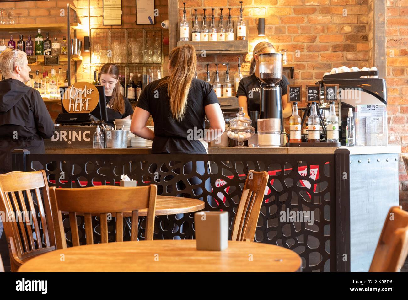 Cafe-Angestellte, alle jungen Mädchen und eine Dame mittleren Alters, die Kaffee bestellt, Ramsbottom, Lancashire, England, UK Summer 2022 Stockfoto