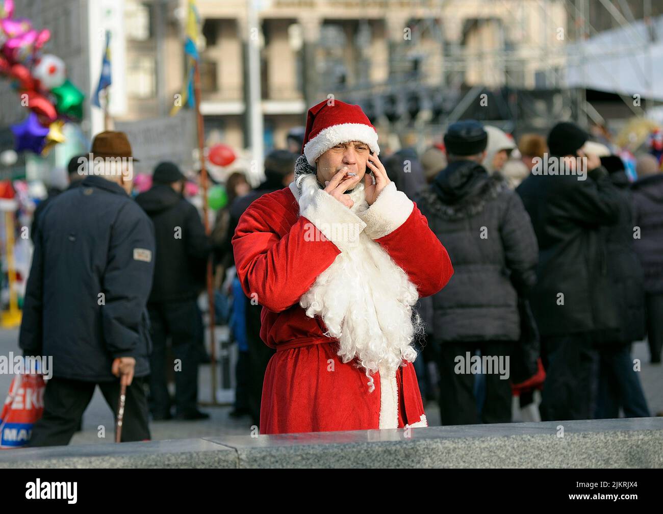Promo Mann gekleidet wie der Weihnachtsmann auf der Straße stehen, rauchen und sprechen auf dem Handy. 30. Dezember 2012. Kiew, Ukraine Stockfoto