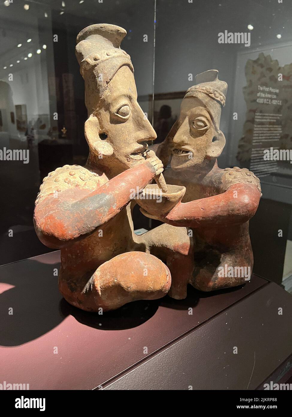 Jalisco-Künstler sitzendes Paar, ca. 100 B.C.E-300 C.E. Mexikanische Keramik, Pigment. Brooklyn Museum. Diese Skulptur eines sitzenden Paares kann eine Hochzeitszeremonie darstellen. Die Frau hält eine Schüssel mit einem unbekannten Getränk für ihren Begleiter, der ihm einen Trinkschlauch in den Mund bringt. Stockfoto