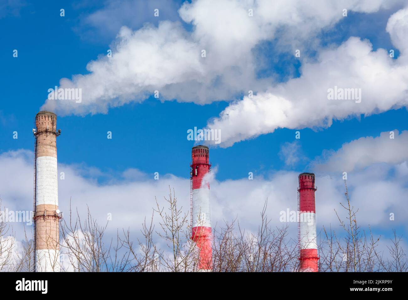 Nahaufnahme der Rohre eines thermischen Kraftwerks mit weißem Dampf im Winter. Wärmeerzeugung an einer Arbeitsstation. Das Konzept der Umweltverschmutzung Stockfoto