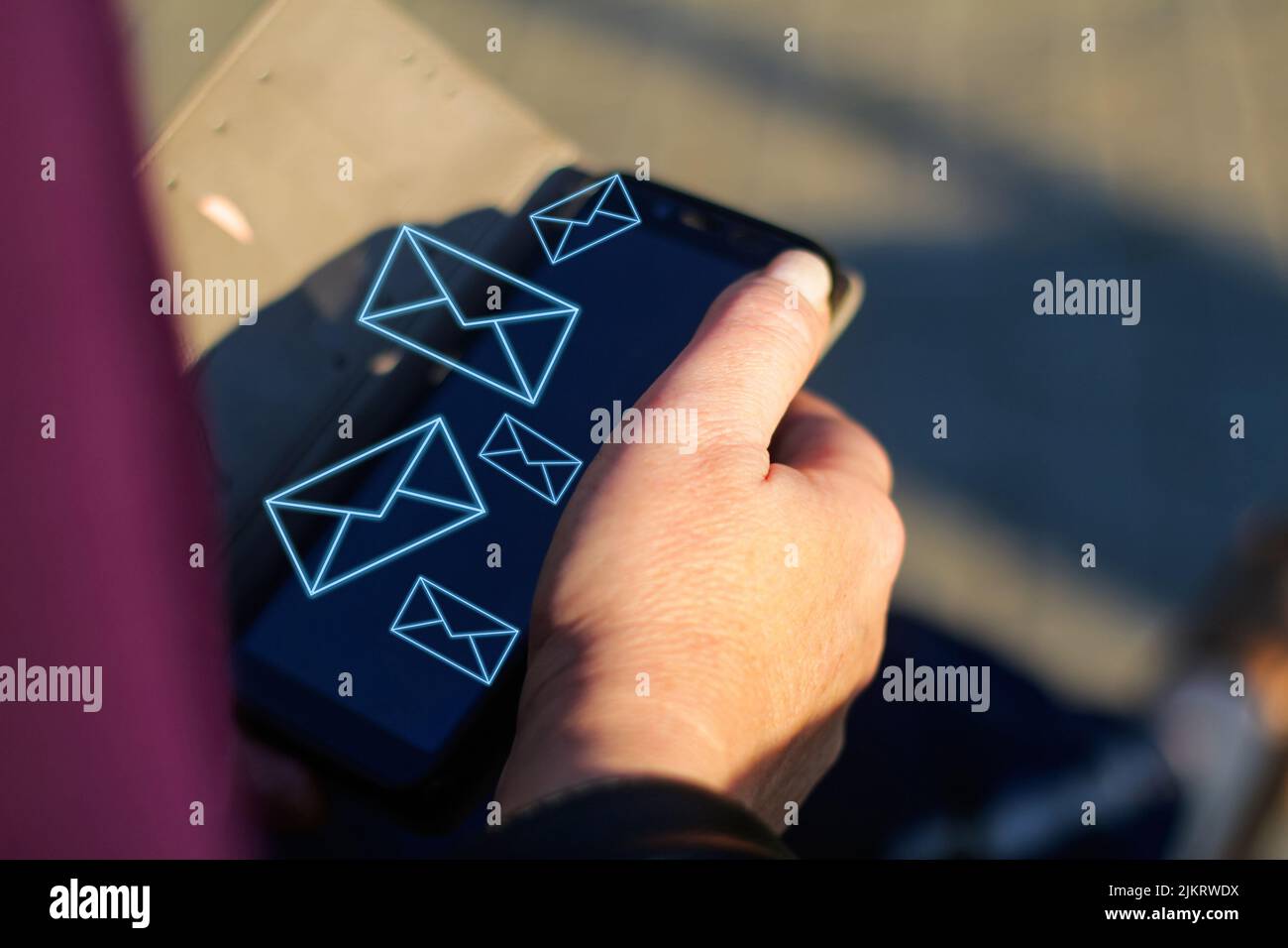 Unschärfe-Unschärfe-Nahaufnahme weibliche Hände suchen auf dem Telefon außerhalb, im Freien. Erwachsene Frau in lila Bluse mit Smartphone, während sie auf einer Bank in der p sitzen Stockfoto