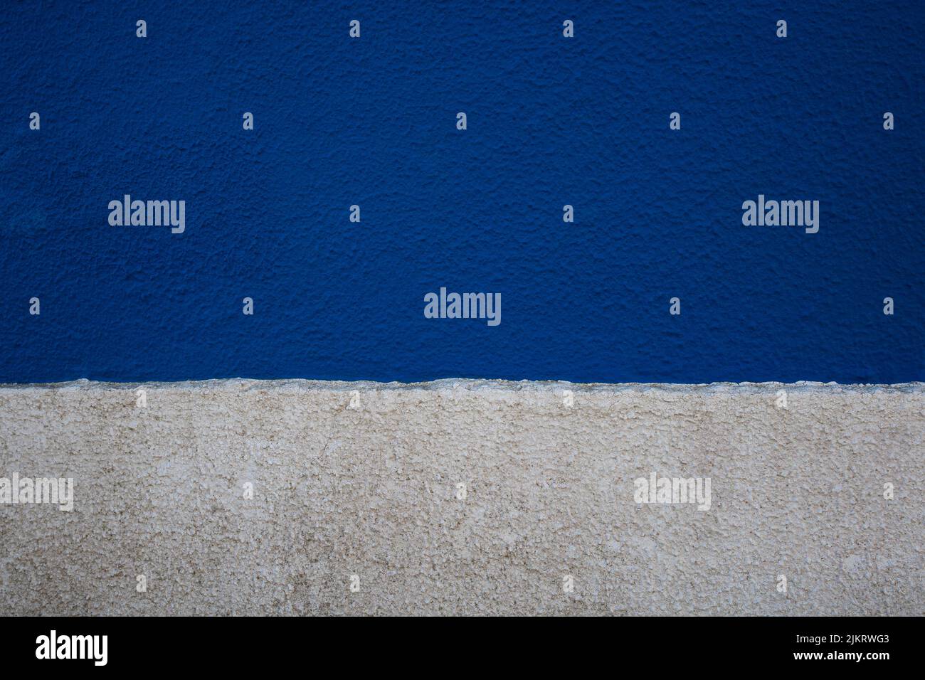 Alte Beton raue Wand Textur in zwei horizontalen Streifen von blauen und weißen Farben lackiert. Abstrakter Hintergrund mit leerem Platz für Text Stockfoto