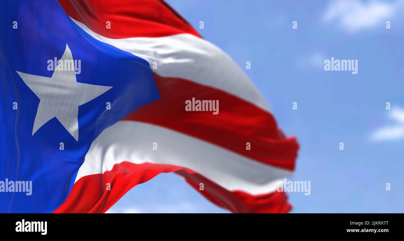 Die Flagge von Puerto Rico winkt an einem klaren Tag im Wind. Puerto Rico ist eine karibische Insel und ein nicht eingebautes Gebiet der Vereinigten Staaten Stockfoto