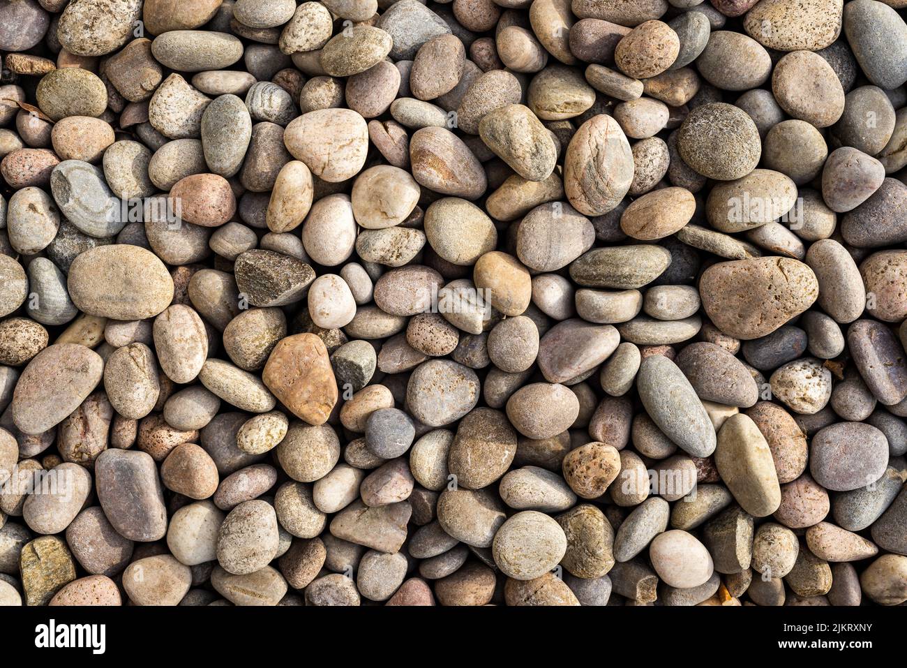 Abstrakte Nahaufnahme von bunten, glatten runden Natursteinen und Kieselsteinen. Stockfoto